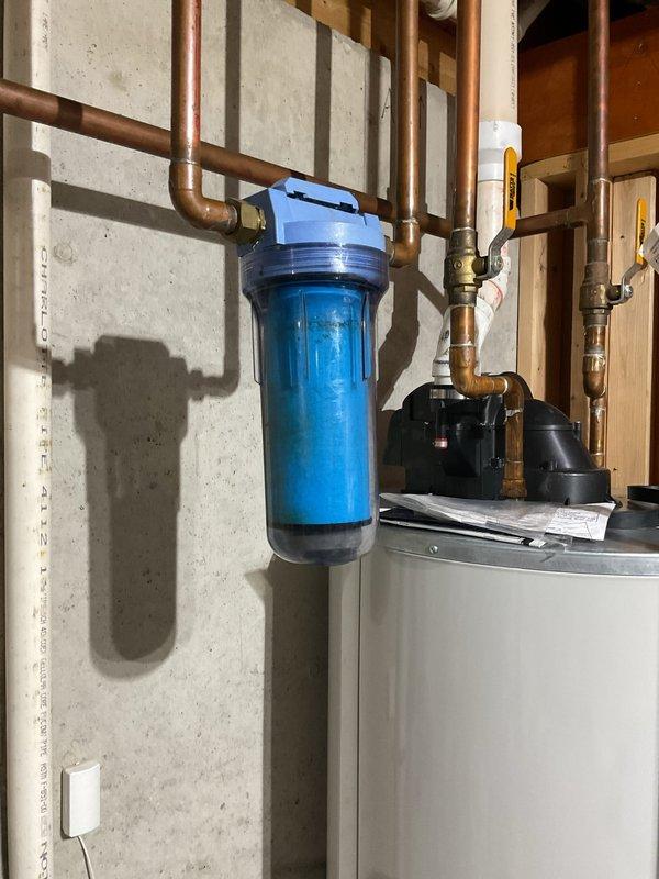 Completed comprehensive furnace and air conditioning clean and check maintenance service. Inspected and serviced all internal components including blower motor, electrical connections, and mechanical assemblies with access panel removed for thorough evaluation. Delivered and installed three replacement water filters for the residential water filtration system, ensuring proper operation of the blue housing unit with brass fittings and shut-off valves.