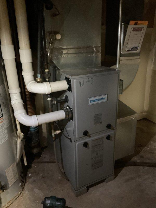 Responded to no cooling complaint on Comfortmaker HVAC system Model N92ESN040141OA1, Serial A20943507J3. Performed diagnostic inspection of furnace and air handler unit in basement installation, verified system specifications and equipment identification. Documented existing installation including PVC condensate drainage system, ductwork connections, and control panel configuration for service records.