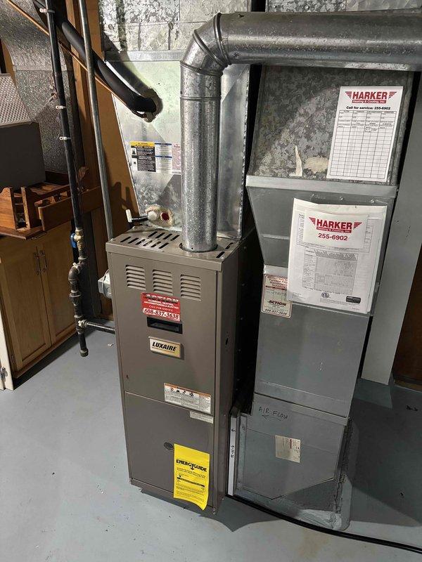 Responded to service call for Luxaire furnace with active water leak occurring during air conditioning operation. Upon arrival, confirmed significant water accumulation on and around 12-year-old furnace unit. Diagnostic inspection revealed condensate drainage issue associated with evaporator coil operation. Temperature differential measurements confirmed cooling system operation with supply air temperature at -4.8°F and return air at 65.7°F, indicating proper refrigerant cycle but improper condensate management. Identified clogged or disconnected condensate drain line as primary cause of water leak. Documented equipment condition and leak source with photographs for service records.
