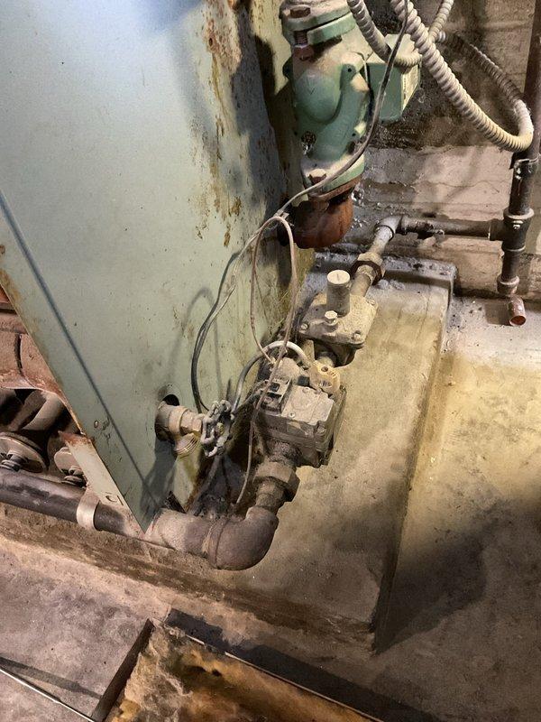 Completed comprehensive clean and check service on 47-year-old boiler system with Intellidyne IntelliCon-HW+ fuel economizer control. Unit exhibits severe deterioration including extensive rust staining, corrosion on circulator pump assembly, degraded piping components, and mineral deposits throughout the system. Strongly recommended complete system replacement due to advanced age and compromised condition of all major components.