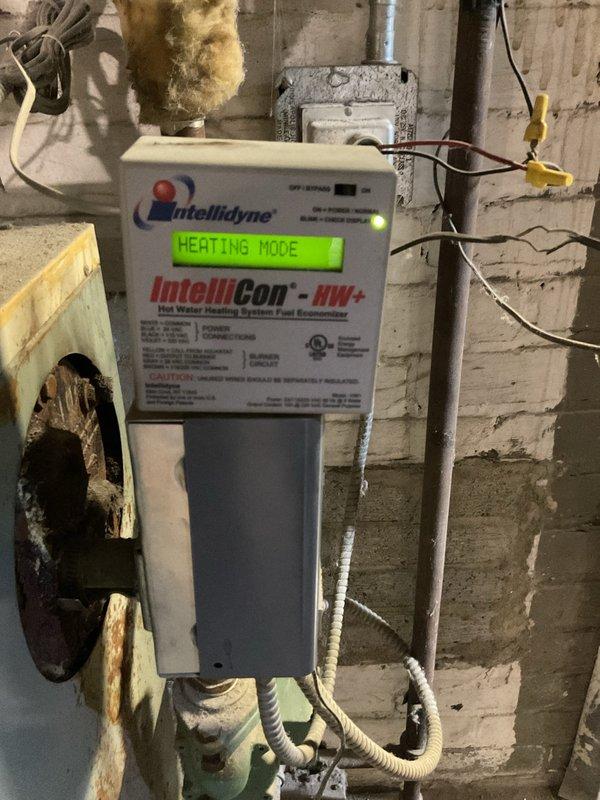 Completed comprehensive clean and check service on 47-year-old boiler system with Intellidyne IntelliCon-HW+ fuel economizer control. Unit exhibits severe deterioration including extensive rust staining, corrosion on circulator pump assembly, degraded piping components, and mineral deposits throughout the system. Strongly recommended complete system replacement due to advanced age and compromised condition of all major components.