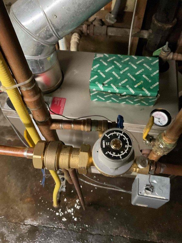 Responded to service call for leaking backflow preventer and automatic fill valve on residential boiler system. Upon inspection, confirmed active leaks at both components with visible water accumulation on basement floor. Removed and replaced failed backflow preventer and fill valve assembly with new components. Reconnected all copper piping connections and verified proper sealing at brass fittings. Adjusted boiler operating pressure to manufacturer specifications and tested system operation. Confirmed no leaks present and proper fill valve function upon completion.