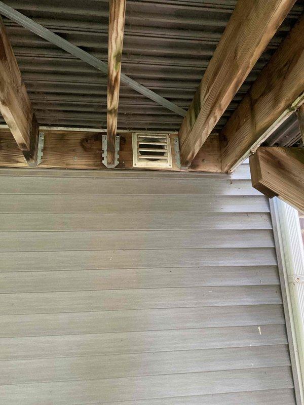 Responded to service call for outside air damper not opening. Upon inspection, discovered damper was completely disconnected and not hooked to any actuator or control mechanism. Documented existing conditions showing exterior soffit-mounted intake vent and interior ceiling register. Identified that damper assembly requires proper connection to operational control system to function as intended for fresh air intake.
