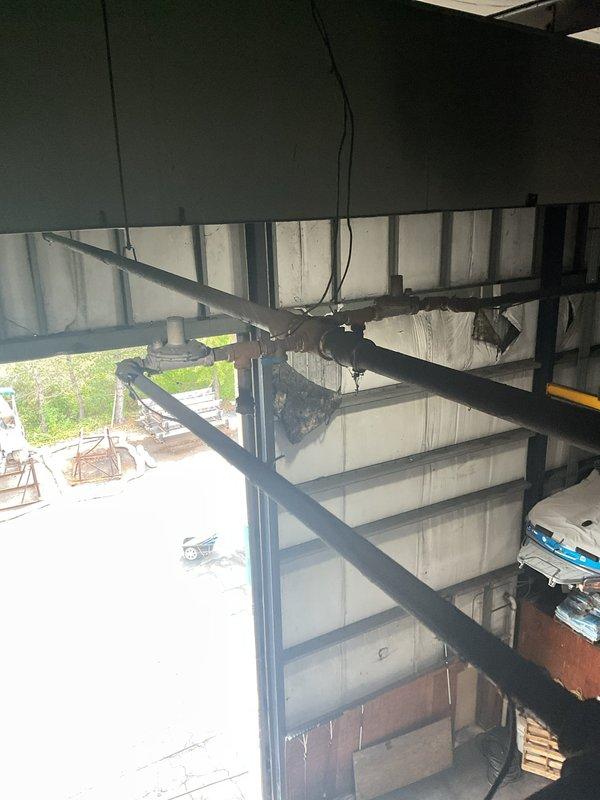 Responded to service call for venting system repairs at industrial warehouse facility. Inspected and assessed deteriorated vent piping on rooftop and at unit heater locations throughout the building. Identified multiple points of venting leaks caused by rotted and corroded pipe sections requiring replacement. Utilized aerial lift equipment to access elevated unit heaters and rooftop penetrations for thorough evaluation. Documented existing conditions with photographs showing extent of deterioration in venting infrastructure. Provided on-site assessment and recommendations for necessary repairs to restore proper venting function and prevent further system degradation.