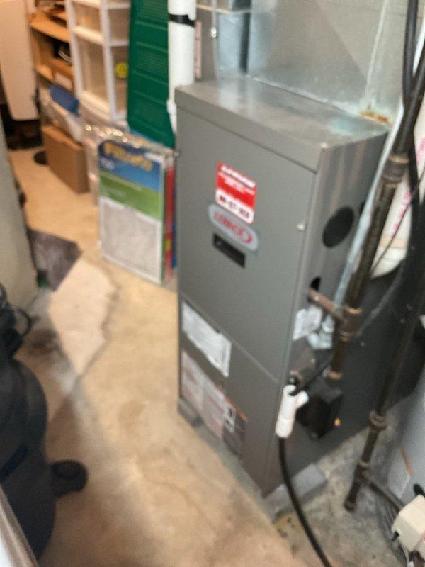 Completed comprehensive furnace clean and check on 20-year-old heating unit. Verified operational performance in heating mode with igniter reading 250 ohms within normal parameters and CO reading at 3 ppm. Performed maintenance including cleaning flame sensor, tightening electrical connections, cleaning pressure switch ports and openings in cold and header box, and cleaning drain trap. Inspected burners and heat exchanger with minimal rust buildup noted despite age of equipment. Confirmed blower fan operation and verified recently changed air filter. Unit operating adequately with all safety systems functioning properly.