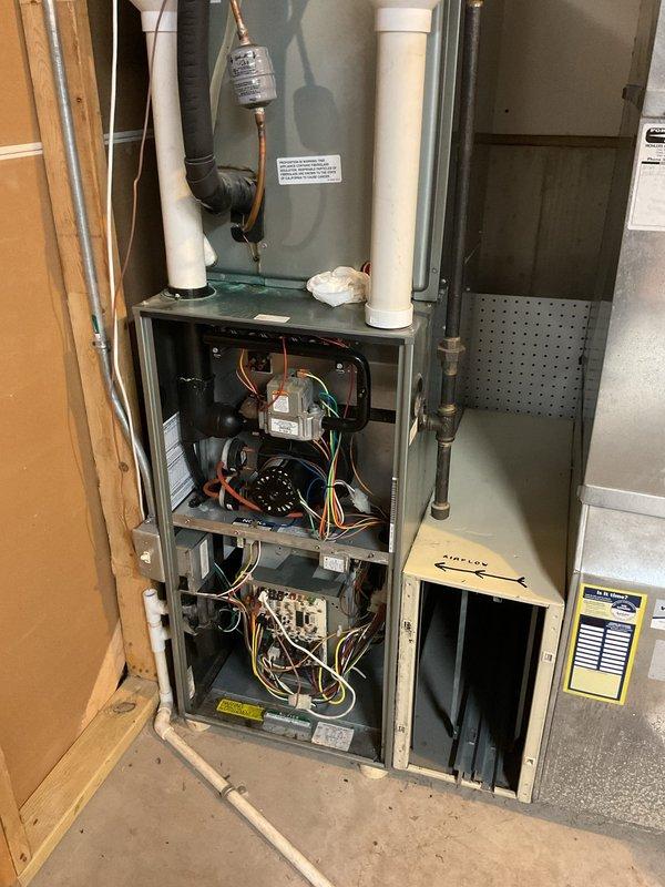 Responded to no heat call on 11-year-old Ruud Achiever 90 Plus furnace. Upon inspection, unit was in poor condition with failed blower motor causing humming noise. Replaced both capacitors initially, but motor continued to hum and failed to operate properly. Diagnosed blower motor as defective and requiring replacement to restore heat. Documented internal components and system condition with photos showing exposed blower assembly, control board, wiring harnesses, and refrigerant lines. Unit temporarily non-operational pending blower motor replacement to provide interim heating solution until full system replacement scheduled.
