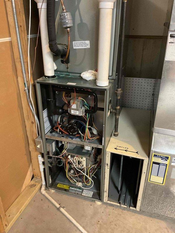 Responded to no heat call on 11-year-old Ruud Achiever 90 Plus furnace. Upon inspection, unit was in poor condition with failed blower motor causing humming noise. Replaced both capacitors initially, but motor continued to hum and failed to operate properly. Diagnosed blower motor as defective and requiring replacement to restore heat. Documented internal components and system condition with photos showing exposed blower assembly, control board, wiring harnesses, and refrigerant lines. Unit temporarily non-operational pending blower motor replacement to provide interim heating solution until full system replacement scheduled.