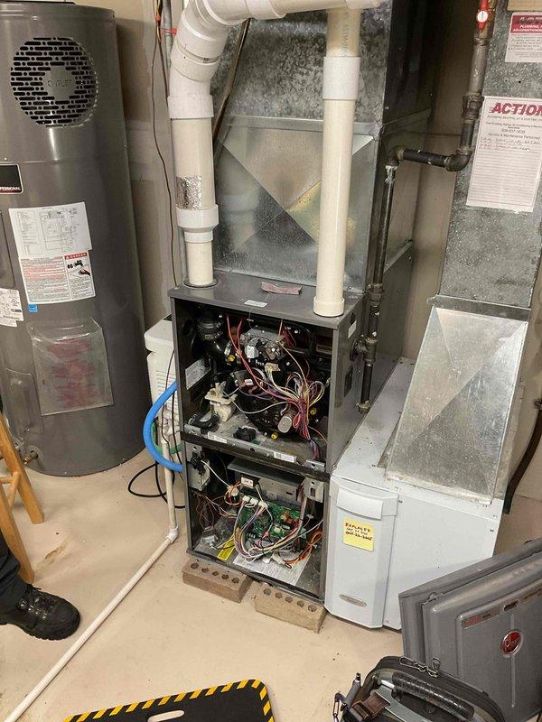 Completed comprehensive furnace tune-up on residential heating unit. Addressed access panel issue by repairing lower door to ensure proper closure. Removed, inspected, and cleaned igniter and flame sensor. Replaced humidifier panel. Inspected and tightened electrical connections on control board and fan motor. Checked pressure switch ports and cleared header box openings. Removed and cleaned condensate drain trap. Verified unit operation and confirmed effective heating performance upon completion.