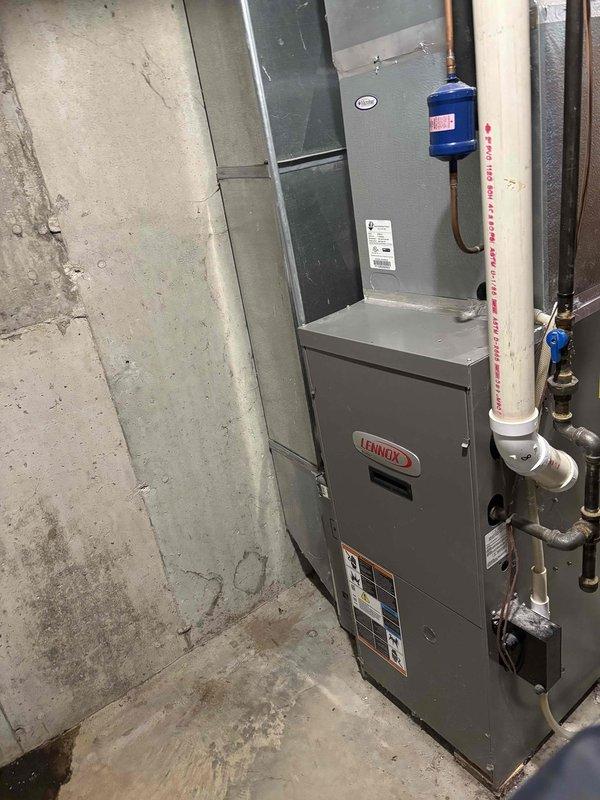 Performed routine air conditioning clean and check service on residential Lennox HVAC system. Inspected outdoor condensing unit with cylindrical cage design and indoor furnace installation in basement. Completed standard maintenance procedures including cleaning condenser coils, checking refrigerant levels, verifying electrical connections, and testing system operation. All equipment found to be functioning properly with no issues identified.