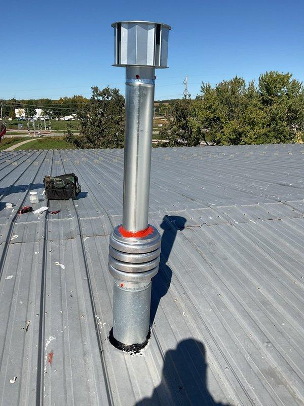 Completed rooftop ventilation system repair by installing new metal vent pipe with proper flashing and weatherproof boot collar on ribbed metal roof. Replaced corrugated vent section and secured all connections to ensure proper exhaust venting and prevent water intrusion. System tested and verified operational with all components properly sealed and fastened.