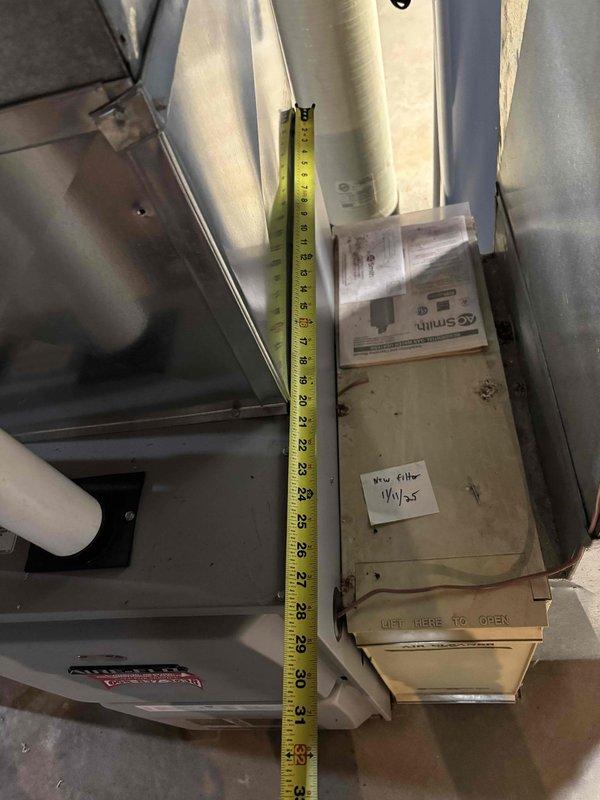 Responded to no heat call on residential furnace system. Upon arrival, inspected aging HVAC equipment in basement installation with extensive ductwork configuration. Performed diagnostic evaluation of gray metal furnace unit and associated air handler system. Measured clearances and documented equipment specifications including filter compartment marked with replacement filter information. System appeared to have standard wear consistent with age. Completed troubleshooting procedures and restored heat operation to residence.