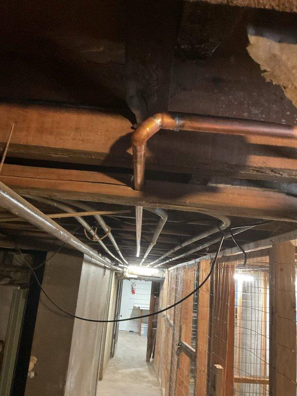 Rerouted boiler supply and return lines that were previously running above electrical boxes, creating a code violation and safety hazard. Reran copper waterlines along alternate path to maintain proper clearance from all electrical components and junction boxes. Secured new piping runs with appropriate hangers and supports to ensure long-term stability and compliance with mechanical code requirements.