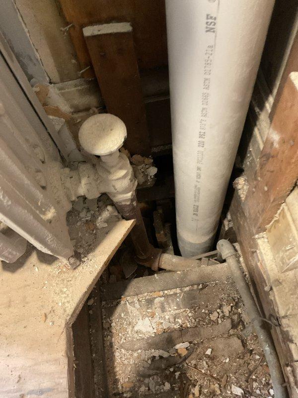 Removed final radiator from steam boiler system and properly capped supply line. Work included cutting access points in wall and ceiling to reach piping, disconnecting radiator connections, and installing permanent caps on steam supply pipes to isolate the removed unit from the active system.