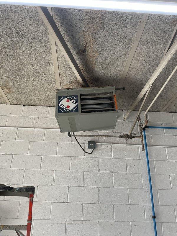 Responded to no heat call for wall-mounted Modine unit heater in shop. Upon arrival, found gas supply to building secured with lock on gas meter, preventing fuel delivery to unit. Documented meter condition and lock placement with photos. Advised customer that gas service must be restored by utility provider before unit can be serviced or operational testing performed.
