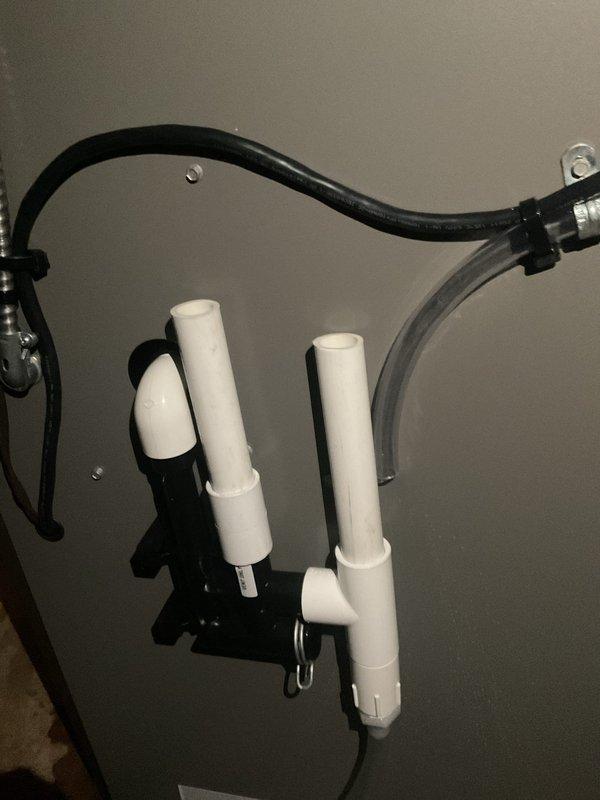 Inspected the high-efficiency condensing furnace and identified water staining and standing moisture on the floor at the base of the unit, along with mineral deposits indicating a recurring condensate leak. Evaluated the condensate drain assembly, including the PVC drain piping, tee fitting, and condensate pump, and verified the drain line and fittings were intact with no visible damage or corrosion. Reviewed thermostat operation with the homeowner, demonstrating programming, mode selection, and temperature setpoint adjustments.