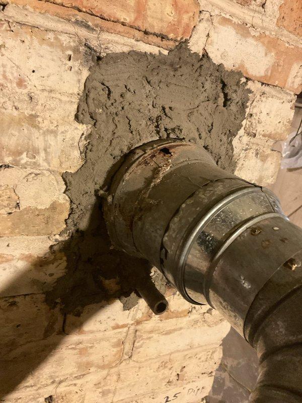 Performed a boiler tune-up and safety inspection, including cleaning and checking the unit's components and operation. Inspection of the flue vent connection at the masonry wall revealed significant rust and corrosion at the pipe collar with perforations and deteriorated surrounding mortar, which should be repaired or replaced to ensure safe venting.