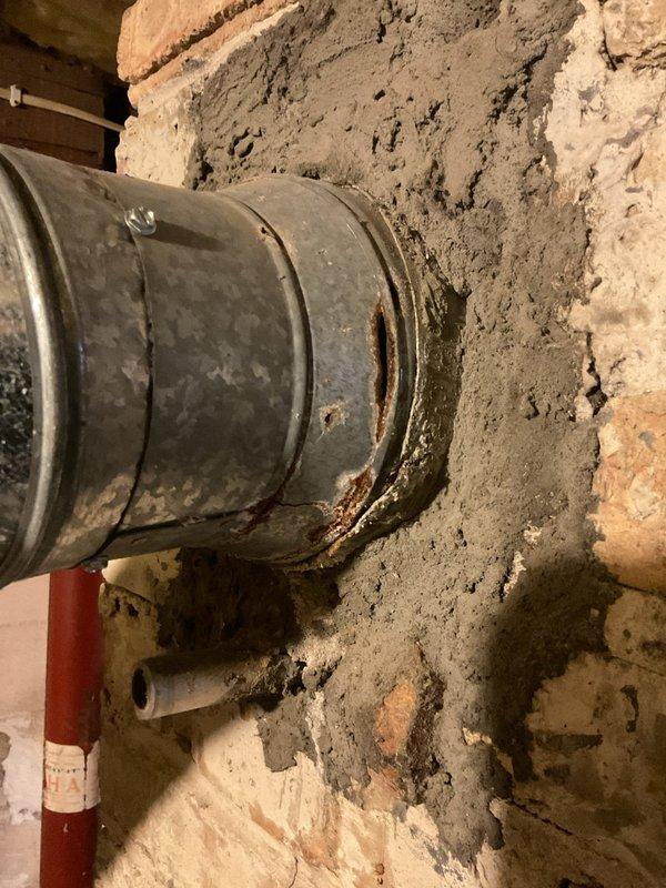 Performed a boiler tune-up and safety inspection, including cleaning and checking the unit's components and operation. Inspection of the flue vent connection at the masonry wall revealed significant rust and corrosion at the pipe collar with perforations and deteriorated surrounding mortar, which should be repaired or replaced to ensure safe venting.