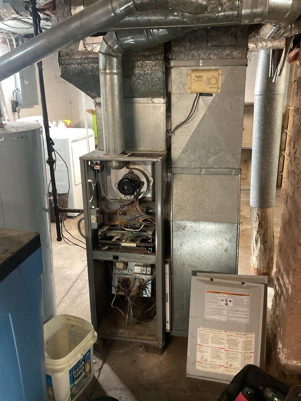 Responded to a no-heat call on a gas furnace where the thermostat was set to 70°F but the space was not warming. Opened the furnace and inspected the inducer motor, pressure switch, burner assembly, gas valve, and control board, noting rust and dust buildup in the burner compartment and loose, unsecured low-voltage wiring in the control area. Performed diagnostics on the ignition sequence and wiring to restore heating operation.