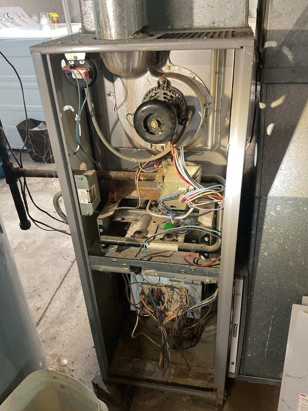Responded to a no-heat call on a gas furnace where the thermostat was set to 70°F but the space was not warming. Opened the furnace and inspected the inducer motor, pressure switch, burner assembly, gas valve, and control board, noting rust and dust buildup in the burner compartment and loose, unsecured low-voltage wiring in the control area. Performed diagnostics on the ignition sequence and wiring to restore heating operation.