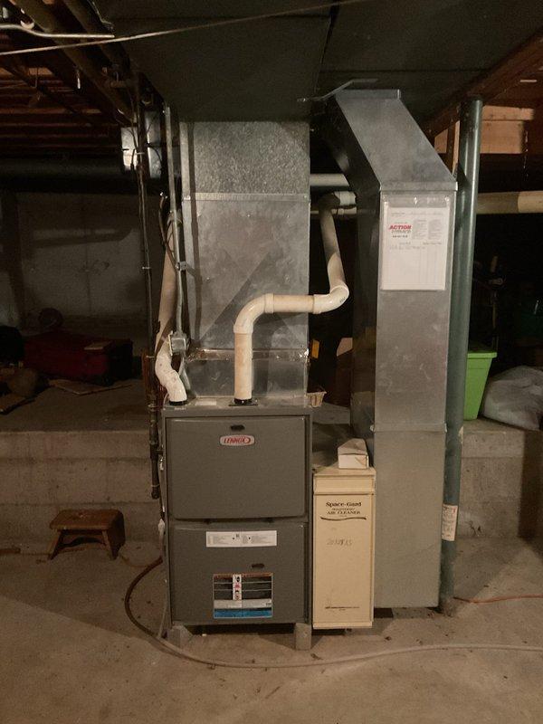Performed a visual inspection of the Lennox gas furnace to verify that recent maintenance was completed correctly, checking the cabinet, access panels, PVC venting, and supply plenum/ductwork, with no evidence of rust, frost, or damage found. Also inspected the outdoor condenser, noting heavy debris and vegetation around the unit that should be cleared to maintain proper airflow.