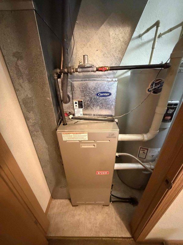 Performed a clean and check on a 2003 Bryant gas furnace, inspecting the burner assembly, heat exchanger, blower assembly, and gas connections for proper operation and safe combustion. Verified the Honeywell programmable thermostat calls for heat and cycles the furnace correctly, and confirmed the gas line, regulator, and shutoff valve are intact with no leaks observed.