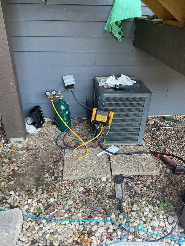 Located and repaired a refrigerant leak in the line set where a nail had punctured the copper tubing inside the exterior wall cavity, accessing the damaged section through an opening cut in the wall sheathing. Following the repair, pressure tested the system with nitrogen to verify leak-free integrity, then evacuated and recharged the A/C system with refrigerant to proper operating levels using a digital manifold gauge set.