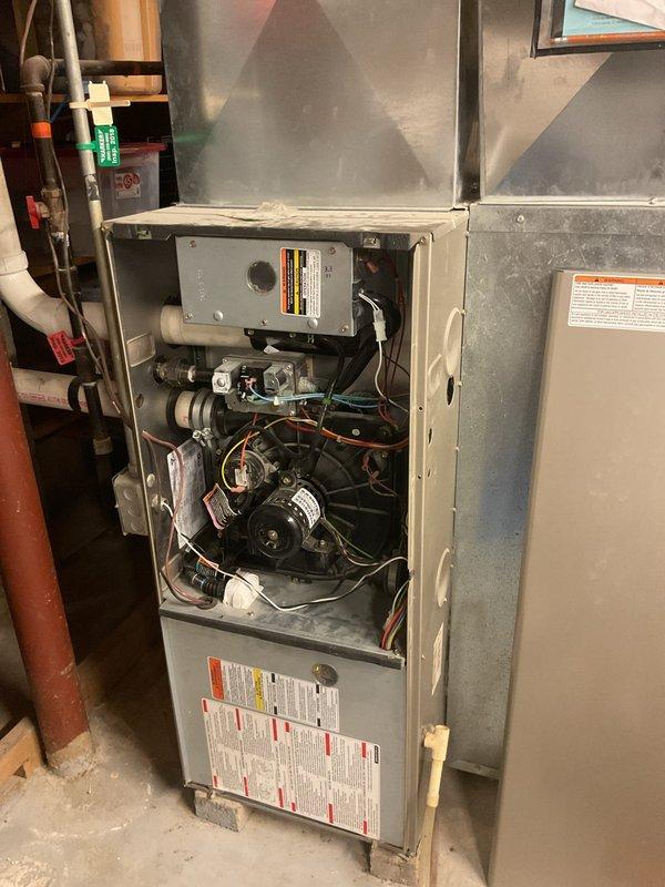 Performed a basic cleaning and inspection on a 2006 Carrier gas furnace, removing the front access panel to inspect the inducer motor, gas valve assembly, control board, pressure switch, wiring, and PVC vent connection. Cleaned light dust and grime from the furnace cabinet and surrounding ductwork, and verified the unit was reassembled and ready for operation.