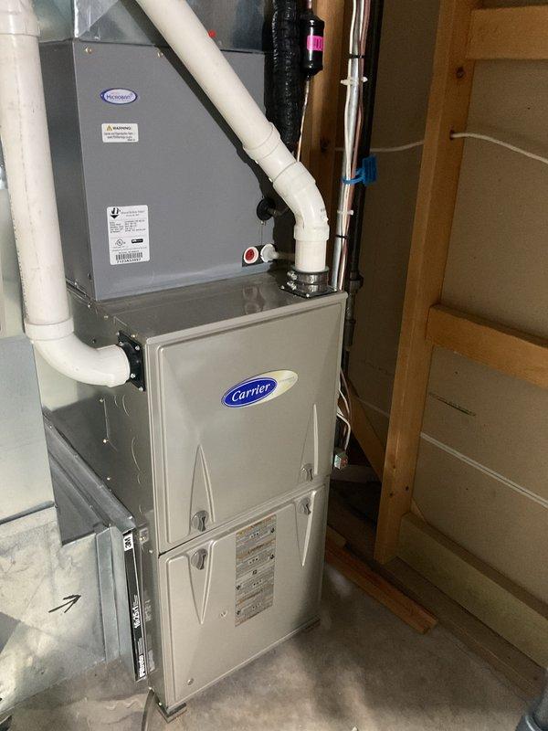 Performed a tune-up on a Carrier gas furnace with a coil cabinet and Aprilaire whole-home humidifier, including inspection of the furnace cabinet, condensate and PVC venting connections, refrigerant line, wiring, and filter slot. No frost, rust, or visible damage was found, and the humidifier installation on the supply plenum, with its bypass duct connection and wiring, was verified. The system was left in good operating condition.