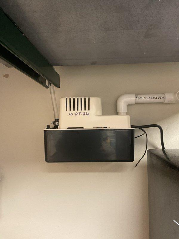 Responded to a reported clanking noise on an AprilAire Model E130 dehumidifier suspended from overhead strut channel and threaded rod. Inspected the unit, mounting hardware, condensate tubing, and condensate pump with PVC discharge line, finding no visible frost, rust, or damage to the equipment. Noted an unterminated electrical lead at the condensate pump and held off on repairs pending customer cost approval.