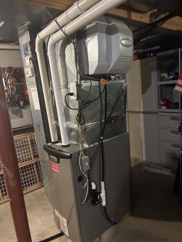 Performed annual heating maintenance on a vertical gas furnace with PVC intake/exhaust venting, cleaning the unit and inspecting the cabinet, condensate drain assembly, and electrical connections. Verified the furnace and attached Aprilaire whole-home humidifier showed no signs of rust, frost, cracking, or damage, and completed the system check with equipment in good working condition.