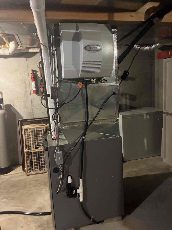 Performed annual heating maintenance on a vertical gas furnace with PVC intake/exhaust venting, cleaning the unit and inspecting the cabinet, condensate drain assembly, and electrical connections. Verified the furnace and attached Aprilaire whole-home humidifier showed no signs of rust, frost, cracking, or damage, and completed the system check with equipment in good working condition.