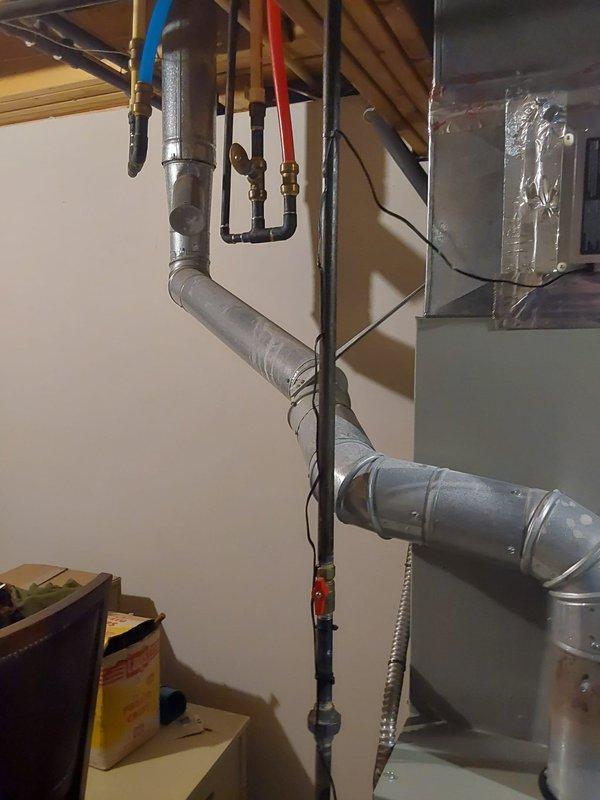 Performed furnace retrofit to address heating failure in residential basement. Installed new gray furnace unit with digital control panel and connected existing ductwork system with proper sealing. Added humidifier/air purifier attachment to improve indoor air quality.