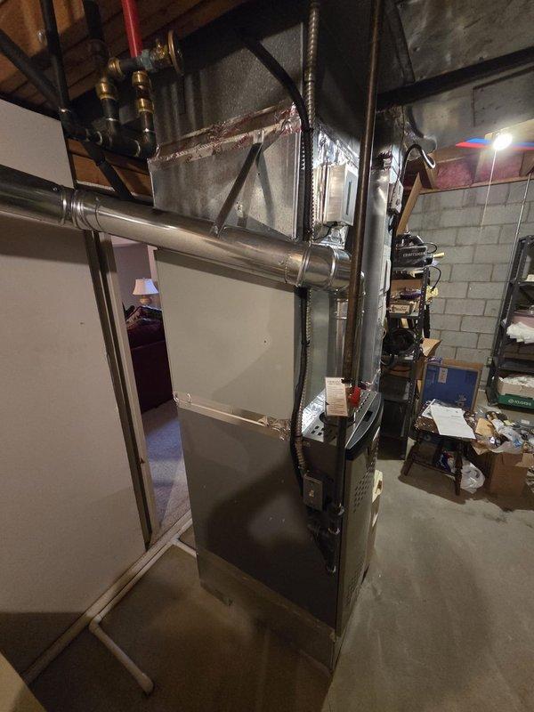 Completed furnace replacement with installation of new Lennox furnace system in basement utility room. Connected system to existing ductwork with proper ventilation pipes and verified all electrical connections. Installed adjacent humidifier unit and confirmed system operation with successful test of indicator lights and controls.