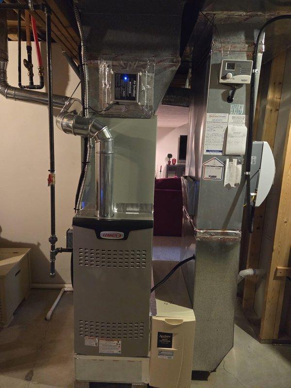 Completed furnace replacement with installation of new Lennox furnace system in basement utility room. Connected system to existing ductwork with proper ventilation pipes and verified all electrical connections. Installed adjacent humidifier unit and confirmed system operation with successful test of indicator lights and controls.