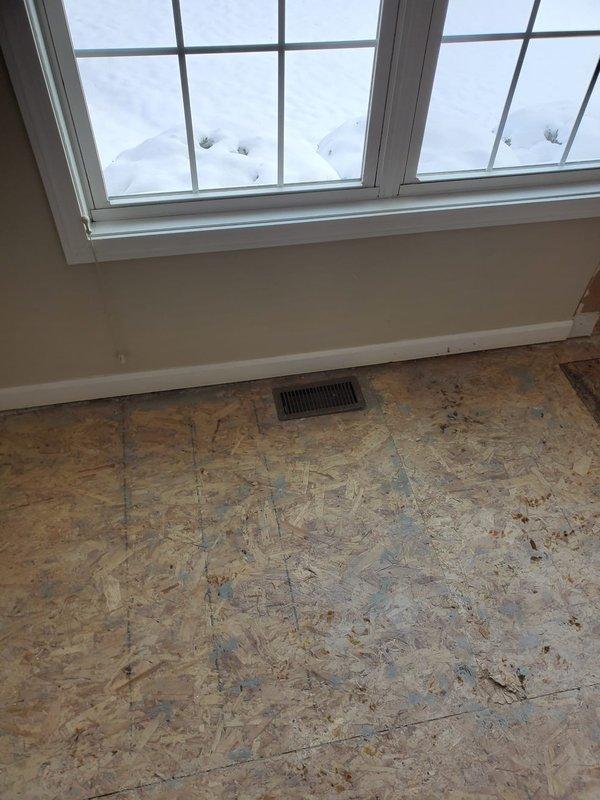 Completed rough-in phase of new construction HVAC installation, including placement of bathroom exhaust fan in ceiling and installation of floor register. Confirmed proper ventilation setup with appropriate ceiling cutouts and verified register positioning according to blueprints.