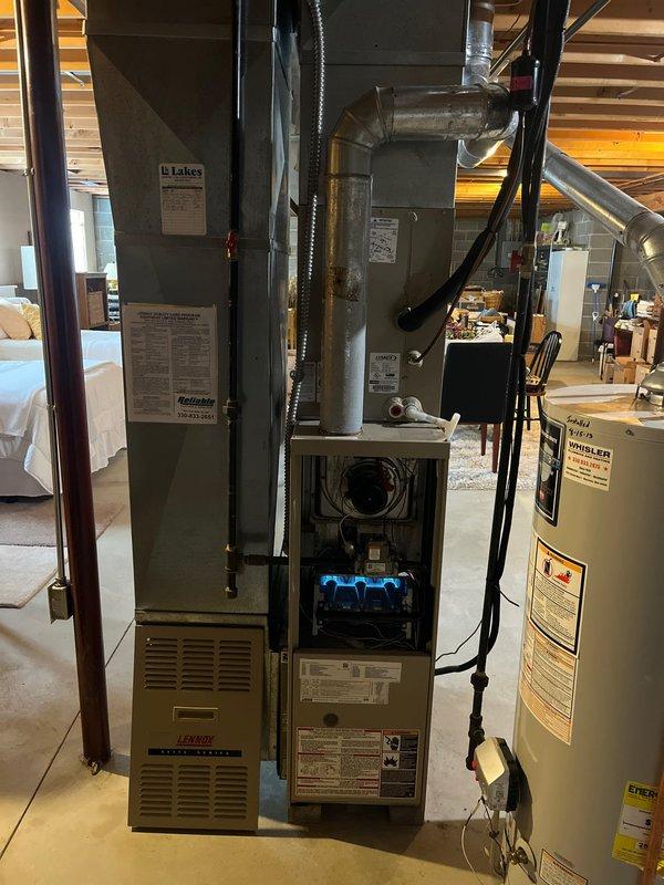 Conducted comprehensive inspection of existing Lennox furnace system in basement utility area. Documented current installation including furnace with visible combustion chamber, connected ductwork, and proximity to water heater with curved vent pipe. Prepared detailed replacement estimate for complete HVAC system upgrade based on observed configuration and space constraints.