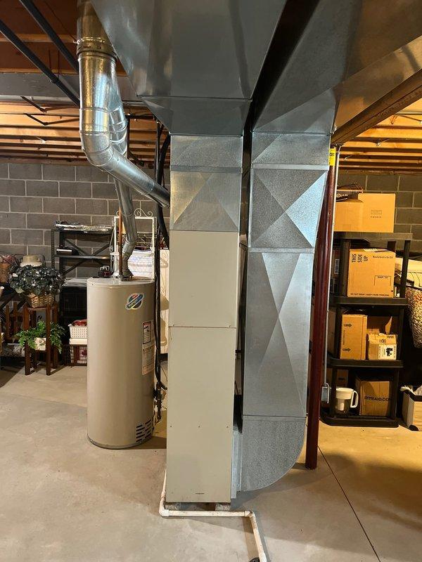 Conducted comprehensive inspection of existing Lennox furnace system in basement utility area. Documented current installation including furnace with visible combustion chamber, connected ductwork, and proximity to water heater with curved vent pipe. Prepared detailed replacement estimate for complete HVAC system upgrade based on observed configuration and space constraints.
