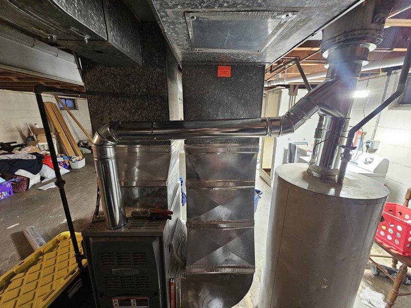 Completed flue pipe repair by addressing significant interior corrosion and rust buildup. Installed new metal ductwork connections to ensure proper ventilation from furnace system to exterior, eliminating potential safety hazards and restoring proper exhaust function.