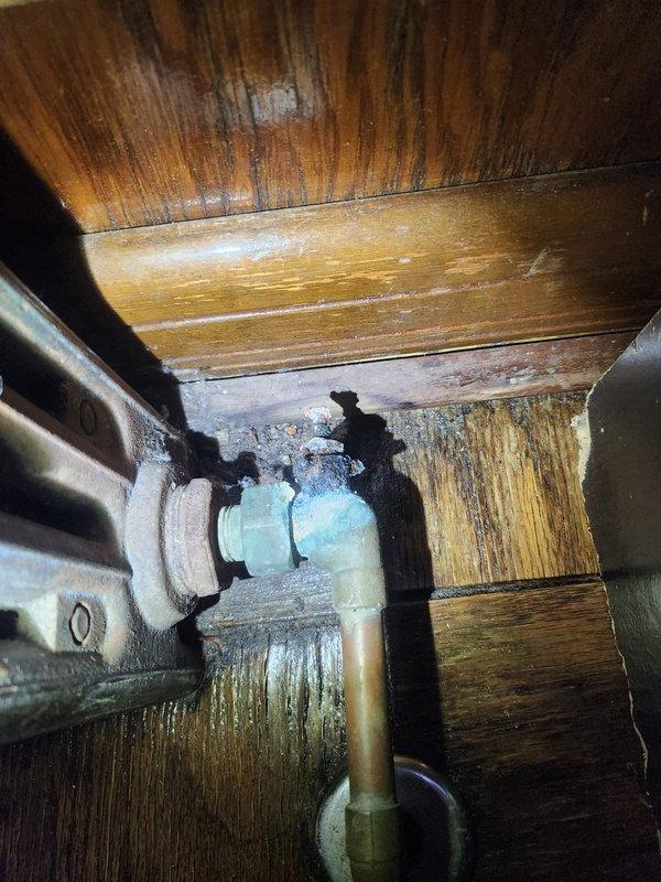 Responded to no-heat complaint at housing unit. Upon inspection, discovered corroded copper piping with significant oxidation and mineral buildup in the furnace's plumbing components. Found water damage to surrounding wooden structure indicating possible long-term moisture exposure. Marked affected sections for future reference after completing necessary repairs to restore heating functionality.