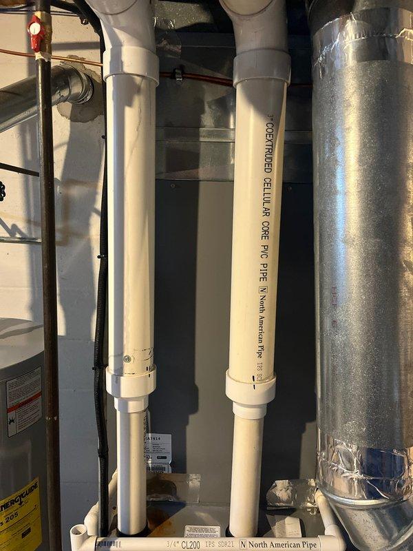 Conducted assessment of 15-year-old furnace for potential replacement. Inspection revealed aging unit with standard efficiency located in basement utility room alongside water heater. Evaluated existing ductwork, PVC venting system, and nearby plumbing to determine compatibility with modern replacement options. Photos documented current installation configuration to facilitate accurate replacement quote.