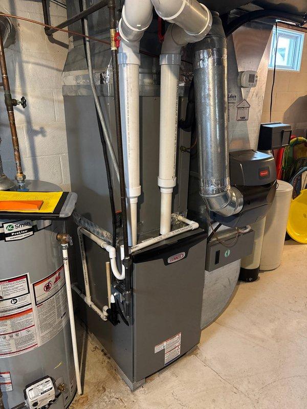 Successfully completed a Lennox furnace retrofit in basement utility area. Installed new unit with proper PVC exhaust venting connected to existing metallic ductwork system. All connections secured and system tested for optimal performance.