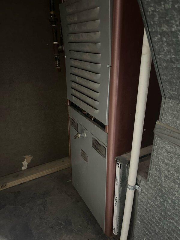 Completed furnace retrofit to replace 45-year-old non-functioning unit with new equipment in basement utility area. Installed modern two-tone furnace with proper PVC venting and connected to existing galvanized ductwork system. System is now operational, resolving the no-heat condition.