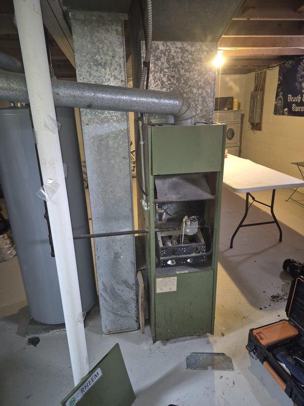 Responded to service call for non-functioning furnace from the 1980s with pilot light issues. Upon inspection of the olive green basement unit, diagnosed faulty pilot assembly. Replaced pilot assembly, cleaned burners, and verified proper ignition sequence. System now operating within normal parameters with strong, consistent flame pattern.