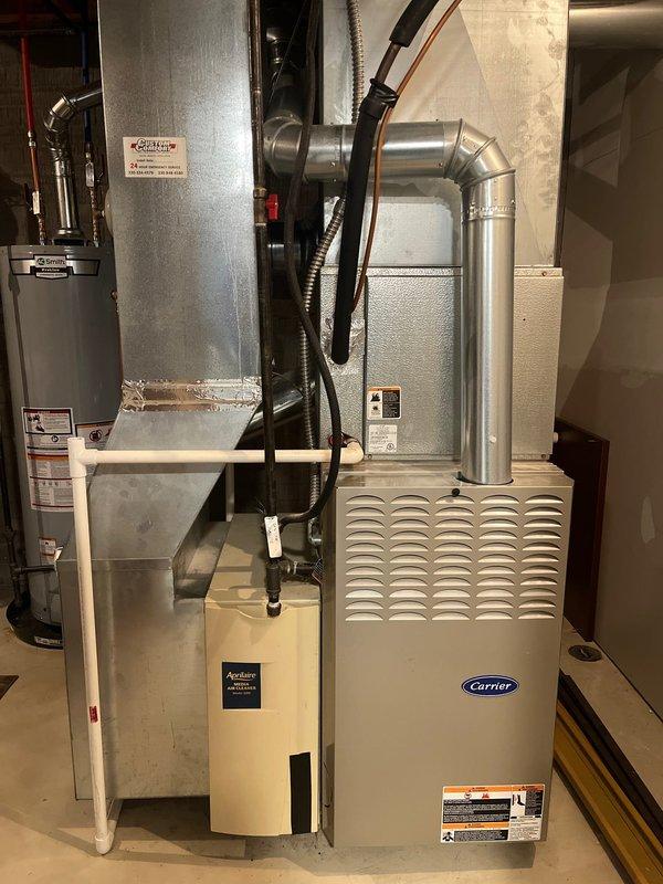 Completed replacement of aging Carrier furnace system (model #58sta090---12116, serial #3305a33590, manufactured August 2005) with new unit. Installation included proper connection of metal ductwork with sealed joints, installation of PVC condensate drain line, and connection of all necessary electrical components. System also features an integrated Aprilaire humidifier mounted to the side ductwork.