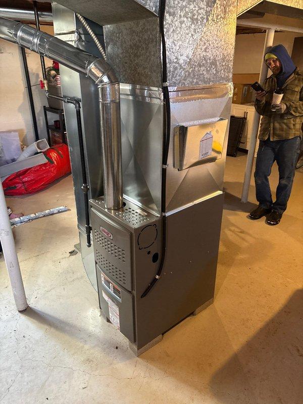 Successfully completed installation of a new Lennox furnace in basement utility area. Installed complete metal ductwork system with proper ventilation connections, including vertical and horizontal galvanized components. System was fully tested and verified to be operating according to manufacturer specifications.