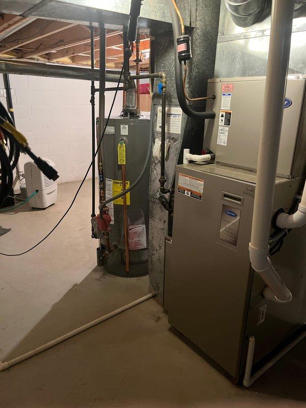 Conducted comprehensive inspection of existing HVAC system in basement utility area. Evaluated aging furnace unit with connected ductwork (both rectangular and circular) and assessed integration with water heater system. Recommended full system replacement due to efficiency concerns and outdated equipment.