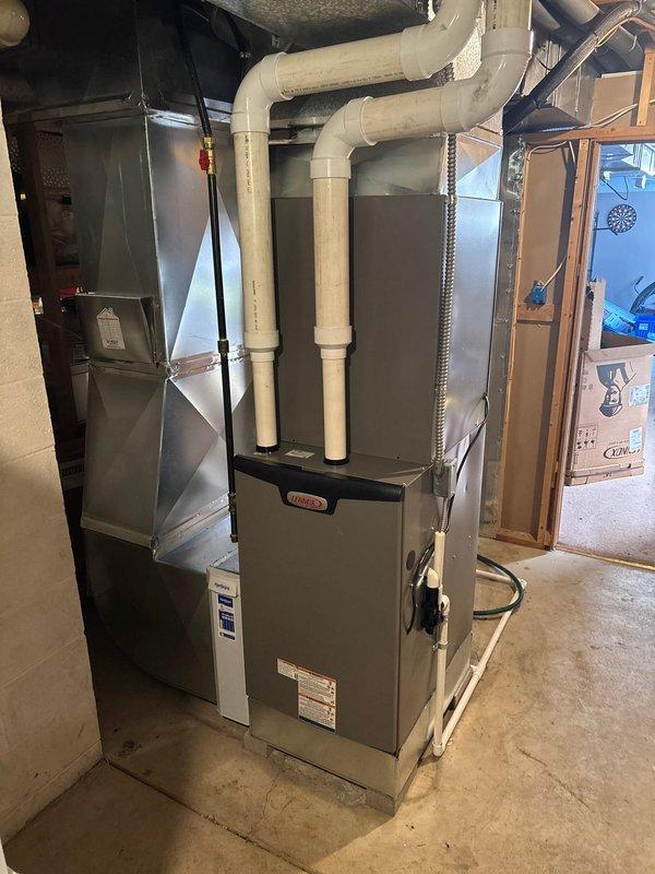 Successfully completed installation of a Lennox residential heating system, converting from geothermal to a conventional furnace with AC. System includes proper PVC venting and ductwork connections in the utility area, with all components securely mounted and professionally installed according to manufacturer specifications.
