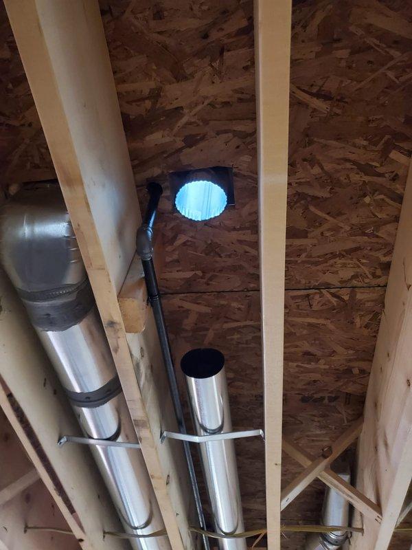 Completed installation of new HVAC ductwork system in unfinished construction space. Installed main supply trunk with properly secured round takeoffs and applied mastic sealant at all connection points to ensure airtight system integrity. Verified proper placement and support of ductwork between structural framing elements.