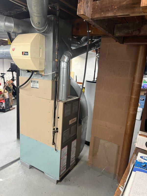 Completed replacement of aging HVAC system in residential basement, including removal of old furnace and installation of new beige/light blue furnace unit with properly connected galvanized ductwork. System was installed with appropriate PVC condensate drainage and all necessary connections to existing distribution network.