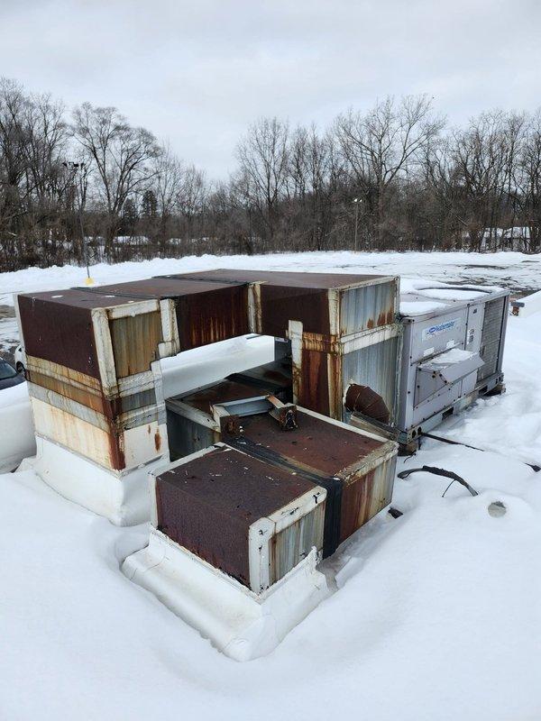 Responded to multiple no-heat calls affecting bar room unit, vending machine thermostat, and pro shop. Inspection revealed severely weathered rooftop units with extensive rust damage and deterioration, likely compromised by harsh winter conditions with visible snow accumulation around equipment. Documented current condition of equipment for potential replacement recommendation.